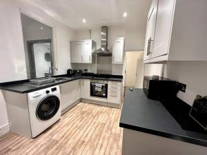 a kitchen with a washing machine and a sink at Modern Mountain Retreat in the Brecon Beacons in Ystradgynlais