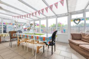a conservatory with a table and chairs and a couch at "PONY POD" at Nelson Park Riding Centre Ltd, St Margarets Road, Woodchurch, Birchington, Kent, CT7 0HJ - GLAMPING POD also available the fox pod and Trailor Escapes- BIRCHINGTON, RAMSGATE, BROADSTAIRS MARGATE in Kent