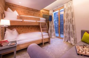 a bedroom with two bunk beds and a couch at Circle Chalets Arlberg in Zug
