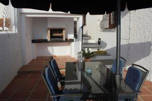 a dining room table with chairs and an umbrella at La Perla in Almuñécar