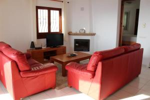 a living room with two red chairs and a television at La Perla in Almuñécar