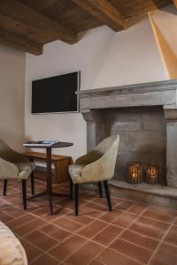 un salon avec une cheminée et une télévision dans l'établissement Monastero Sant'Alberico Relais, à Balze