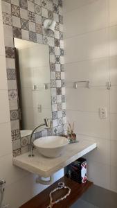 a bathroom with a sink and a mirror at Milagres de Minas in São Miguel dos Milagres