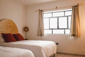 een slaapkamer met 2 bedden en een raam bij Casa Amma - Amma in Matehuala