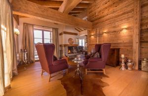 - un salon avec des murs en bois, une table et des chaises dans l'établissement Circle Chalets Arlberg, à Zug