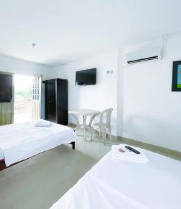 Zimmer mit 2 Betten, einem Tisch und Stühlen in der Unterkunft Luz de Luna Hostal in Tesalia