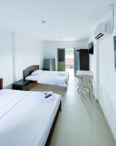 ein Hotelzimmer mit 2 Betten und einem TV in der Unterkunft Luz de Luna Hostal in Tesalia