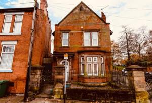 an old brick house with a gate in front of it at Holiday Lodge, close to Nottingham City Centre in Nottingham