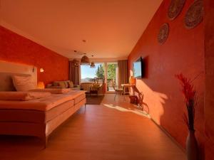 a bedroom with red walls and a bed and a living room at Hotel Berghof Graml in Hallwang