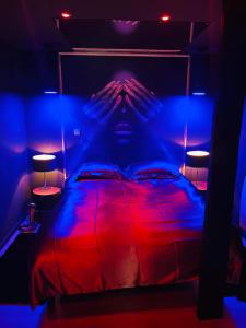 1 dormitorio con 1 cama con luces rojas y azules en Chambre Noire, en Solre-le-Château