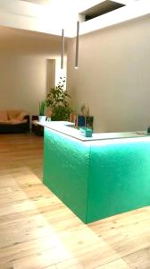 a lobby with a green counter in a room at La Smeralda - Boutique Rooms and Breakfast in Golfo Aranci