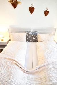 a bedroom with a white bed with hearts on the wall at Doppelzimmer mit Terrasse in Därligen