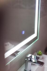 een wastafel in de badkamer met een temperatuurbord op een spiegel bij AVA PROPERTY RENTALS in Făgăraş