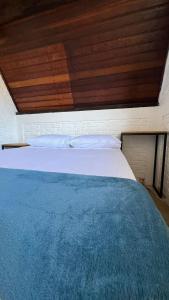uma cama grande num quarto com tecto em madeira em Chale Bombinhas/Borto Belo em Porto Belo