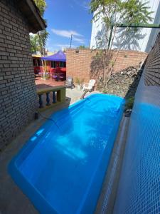 a large blue swimming pool in a backyard at Hostel Ruca Potu in Mendoza