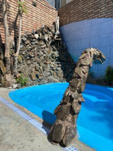 una estatua de un caballo junto a una piscina en Hostel Ruca Potu en Mendoza