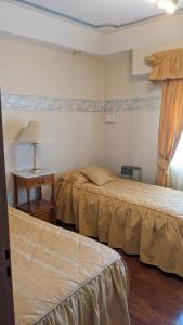 a hotel room with two beds and a table at Casa Pampa in Sarmiento +23 photos