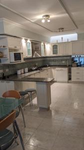 a large kitchen with white cabinets and a large island at Casa Pampa in Sarmiento +23 photos