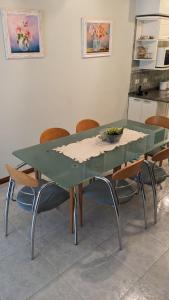 a green table with chairs and a bowl of grapes on it at Casa Pampa in Sarmiento