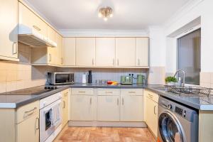 a kitchen with white cabinets and a washer and dryer at 20pct OFF LONG STAYS CONTRACTORS Welcome Chantry close stay in Peterborough
