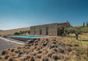 a house with a swimming pool in the middle of a field at Podere San Pasquale in Castiglione dʼOrcia