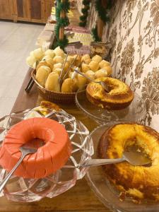 a table topped with pies and other pastries on plates at Hotel central campo grande in Campo Grande