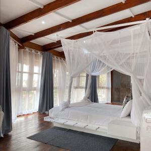 ein Schlafzimmer mit einem weißen Bett mit Baldachin in der Unterkunft Samara Lodge in Vilankulo