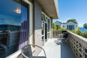 a balcony with two chairs and a computer on it at Stay in Town in Taupo