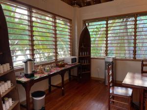 eine Küche mit einem Tisch und einigen Fenstern in der Unterkunft Hotel Guanaja in Guanaja