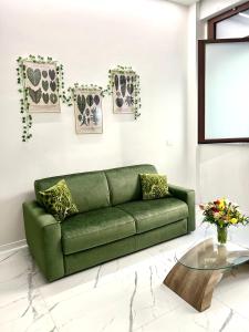um sofá verde numa sala de estar com uma mesa em 0M Plant Turin em Turim