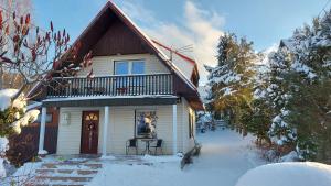 a house with a balcony in the snow at Cottage Zawoja z Jacuzzi in Zawoja