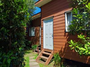 a tiny house with a white door and a staircase at Borde Lago IV - V in Puerto Varas