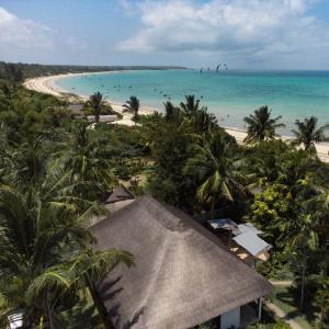 - une vue sur la plage bordée de palmiers et l'océan dans l'établissement Samara Lodge, à Vilanculos