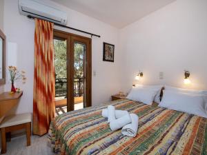 a bedroom with a bed with white sheets and a window at Snug holiday home in Pagkalohori in Pangalochori