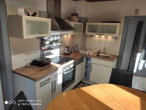 a small kitchen with white appliances and a wooden table at Nice small house in beautiful Carinthia in Feistritz im Rosental