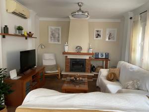 een woonkamer met een bank en een tv bij Casa Rosi, vistas al mar, piscina privada y A/A in Nerja