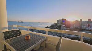 a table on a balcony with a view of the ocean at STAY Sky Apartment in Limassol