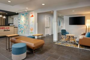 a waiting room at a clinic with a couch and chairs at TownePlace Suites Dulles Airport in Sterling