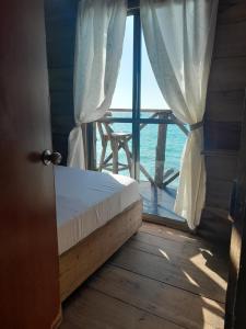una camera da letto con finestra affacciata sull'oceano di Mi Cabañita Guest House a Playa Blanca