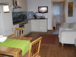 a kitchen and living room with a table and a couch at Apart Ahorn in Finkenberg