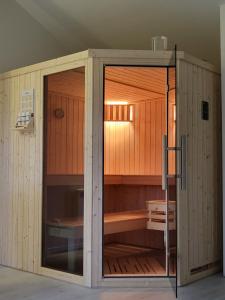 una grande sauna in legno con porta in vetro di Peenehof Köppen - Schlaffässer Hannah oder Jette a Jördenstorf Altre 12 foto