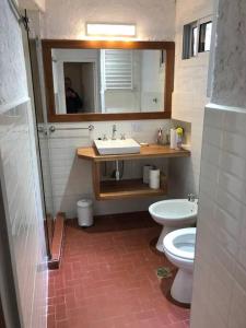 a bathroom with a sink and a toilet and a mirror at Casa Sacriste/ Familia Ahualli in Yerba Buena