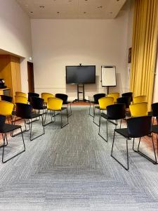 an empty room with chairs and a projection screen at Best Western Plus Hôtel Colbert in Châteauroux