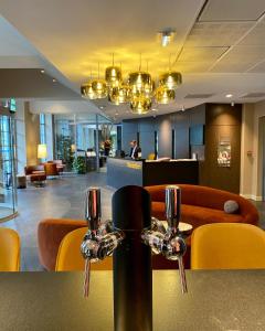hol hotelowy ze stołem i żółtymi krzesłami w obiekcie Best Western Plus Hôtel Colbert w mieście Châteauroux