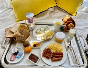 a tray of breakfast foods on a bed at Best Western Plus Hôtel Colbert in Châteauroux