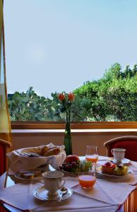 une table avec des assiettes de nourriture et un vase de fleurs dans l'établissement Villa Margherita, à Cefalù