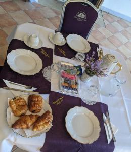 una mesa con platos blancos y pasteles. en Château de la Rocherie en Varennes Vauzelles