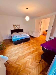 een woonkamer met een bed en een houten vloer bij Villa Traun in Bad Ischl