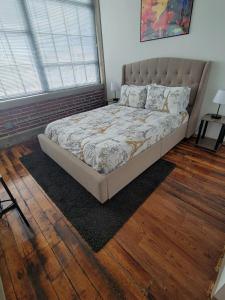 a bed in a bedroom with a wooden floor at Luxe Art Gallery in Saint Louis