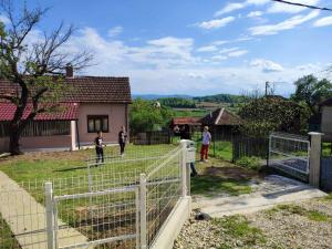 eine Gruppe von Menschen, die in einem Garten neben einem Zaun stehen in der Unterkunft Kuca na kraju sela in Valjevo